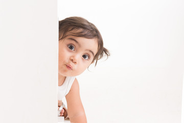 Little princess girl sending kisses behind white board