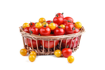 Yellow and red tomatoes lie in basket on a white background.