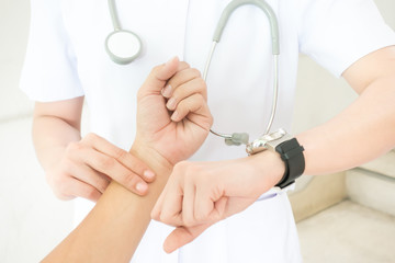 Nurse taking  the patient's pulse hand on white background