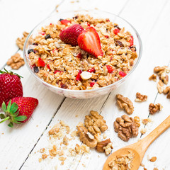 Oatmeal porridge with blueberries, strawberries, nuts and muesli on wooden table. Flat lay. Top view.