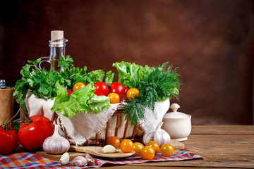 Still life of fresh tomatoes, garlic and parsley on wooden boards.