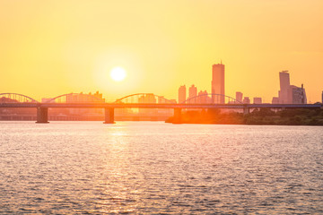 Sunsets behind the skyscrapers of yeouido and bridges across the Han River in South Korea.