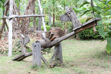 Wooden seesaw made from cart wheels.
