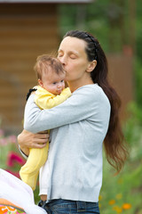 Mother and baby daughter walking in summer park