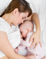 Obraz na płótnie Canvas mother breast feeding and hugging her baby