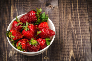 abundance of shiny of strawberry on a dark table/abundance of shiny of strawberry on a wooden table