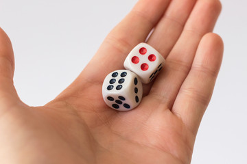 White Dice on hand on light background