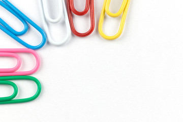 Colored clips on white paper, with nice paper texture