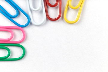 Colored clips on white paper, with nice paper texture
