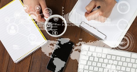 Businessman writing while holding coffee cup 