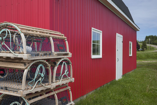 Lobster traps beside bright red painted shed, Prince Edward Island, Canada