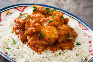 Chicken tikka masala with rice on wooden background

