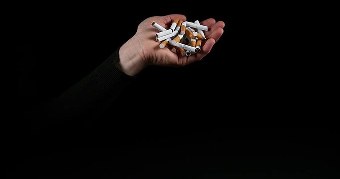 Hand of Man and Broken Cigarettes on Black Background, Slow Motion 4K