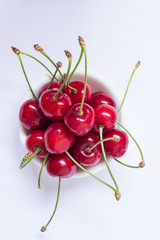 Obraz na płótnie Canvas Red cherries in a plate, close up, top view