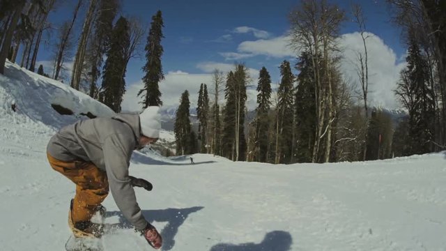 Active man snowboarder riding on slope.