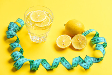 fight against excess weight concept. measuring tape, lemon, glass