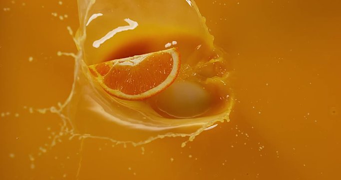 Orange, citrus sinensis, Fruit falling into Orange Juice, Slow Motion 4K