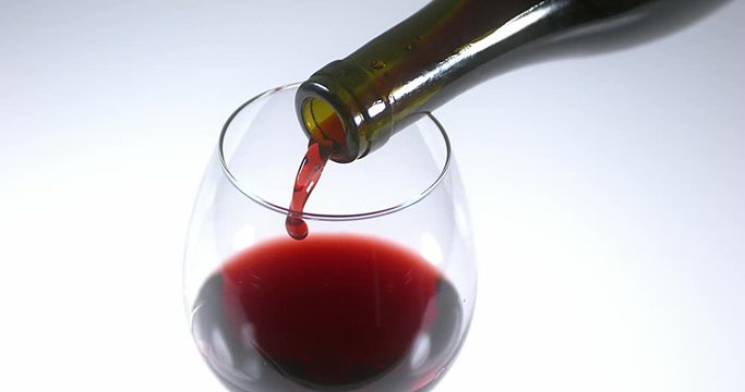 Red Wine being poured into Glass, against White Background, Slow motion 4K