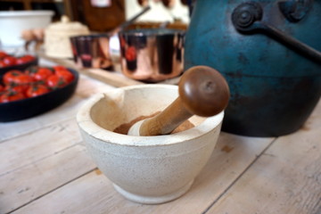 Shallow focus image of a vintage mortar and pestle in a rustic table setting
