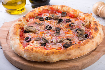 Whole baked pizza on wooden board