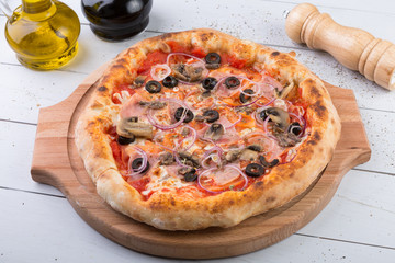Whole baked pizza on wooden board