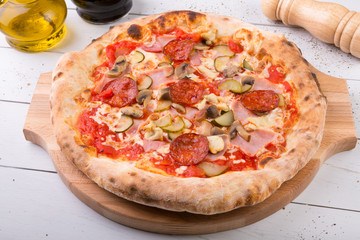 Whole baked pizza on wooden board