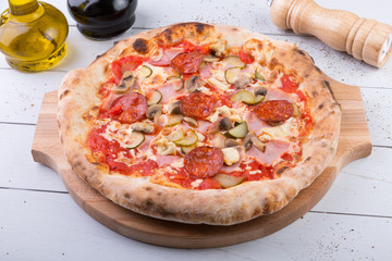 Whole baked pizza on wooden board