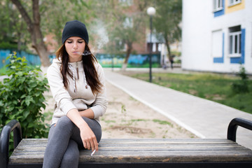 Young girl smoking cigarette outdoors.