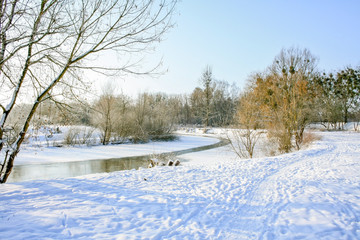 Landscape of river turn  with snow winter road aside frozen river during sunny day.