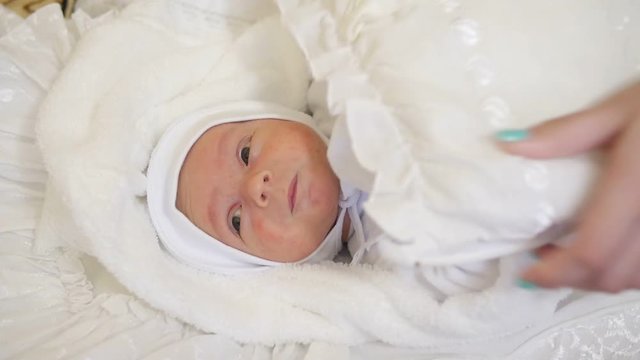 Close up of a newborn wrapped in a white towel