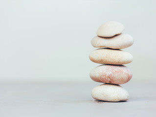 Fototapeta na wymiar a stack of smooth pink stones on a gray background with space for text