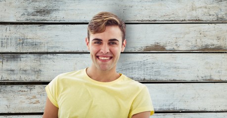 Portrait of man smiling over wooden wall