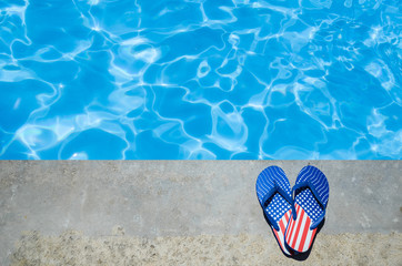 Naklejka premium Summer background with flip flops near the pool