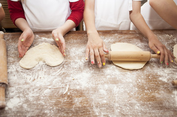 Making pastries from dough with stuffing. Children's hands close-up.
