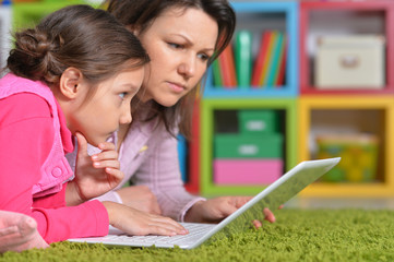 Mother with her daughter enjoying a laptop