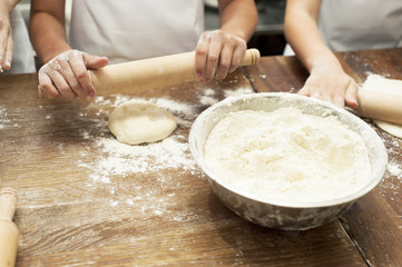 Making pastries from dough with stuffing. Children's hands close-up.