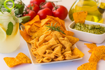 Homemade lemonade with salsa guacamole with corn chips and vegetables