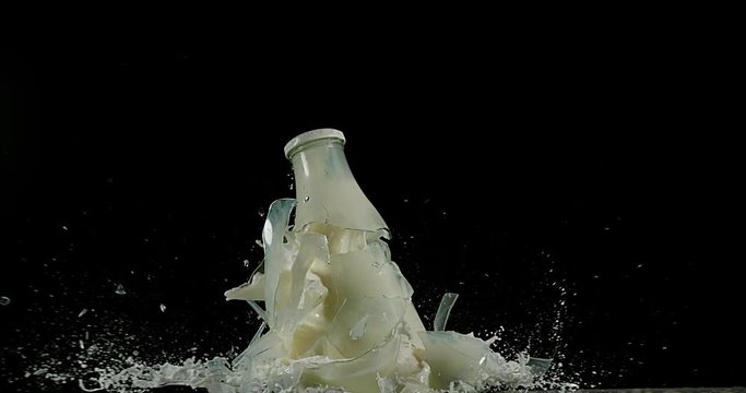 Bottle of Milk Exploding against Black Background, slow motion 4K