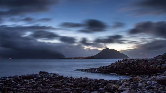 Beautiful landscape of sea and mountains. Long exposure with blurred clouds and clear water. Nordic.