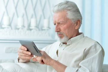 Fototapeta premium Elderly man using a tablet computer