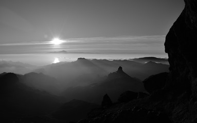 Silhouettes of mountains at sunset, summit of Gran canaria, Roque Bentayga and Tenerife island in the distance, Canary islands, monochrome mode