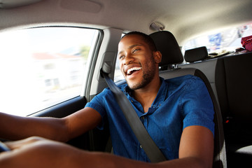 Young african man enjoying driving a car