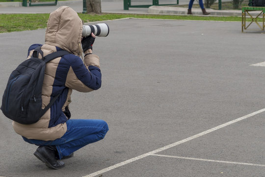 Man photographed something on a white camera with a long lens