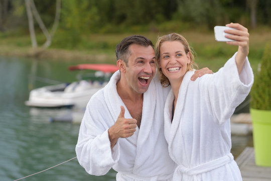 middle-age couple on lake makes a selfie