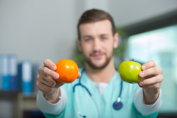 doctor holding an apple and orange in his hands