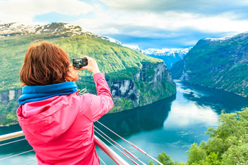 Tourist taking photo from Flydasjuvet viewpoint Norway