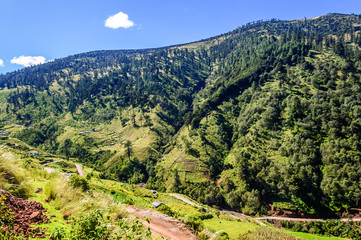 Road winds through forested hills in highlands of Huehuetenango, Guatemala, Central America