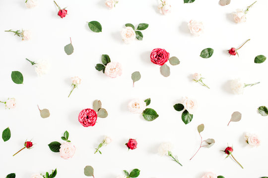 Floral pattern made of red and beige roses, green leaves, branches on white background. Flat lay, top view. Valentine's background. Pattern of flowers. Texture