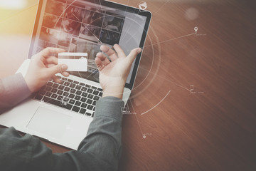 top view of Hand using credit card and laptop computer on wooden desk with VR icon chart graph diagram