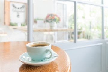 Cup of hot black coffee on Wood Table near window in living room
